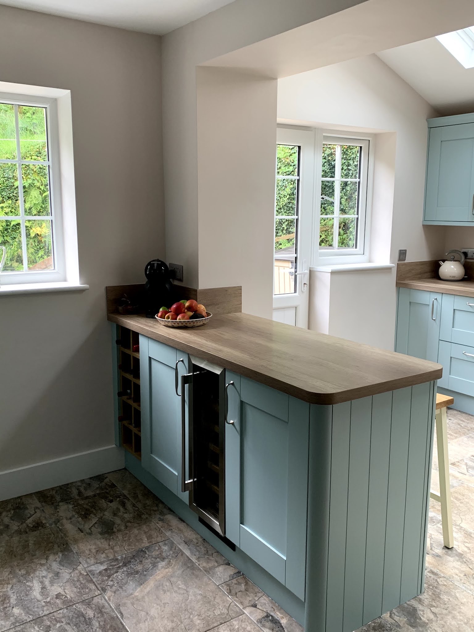 Sage green customer kitchen with a breakfast bar