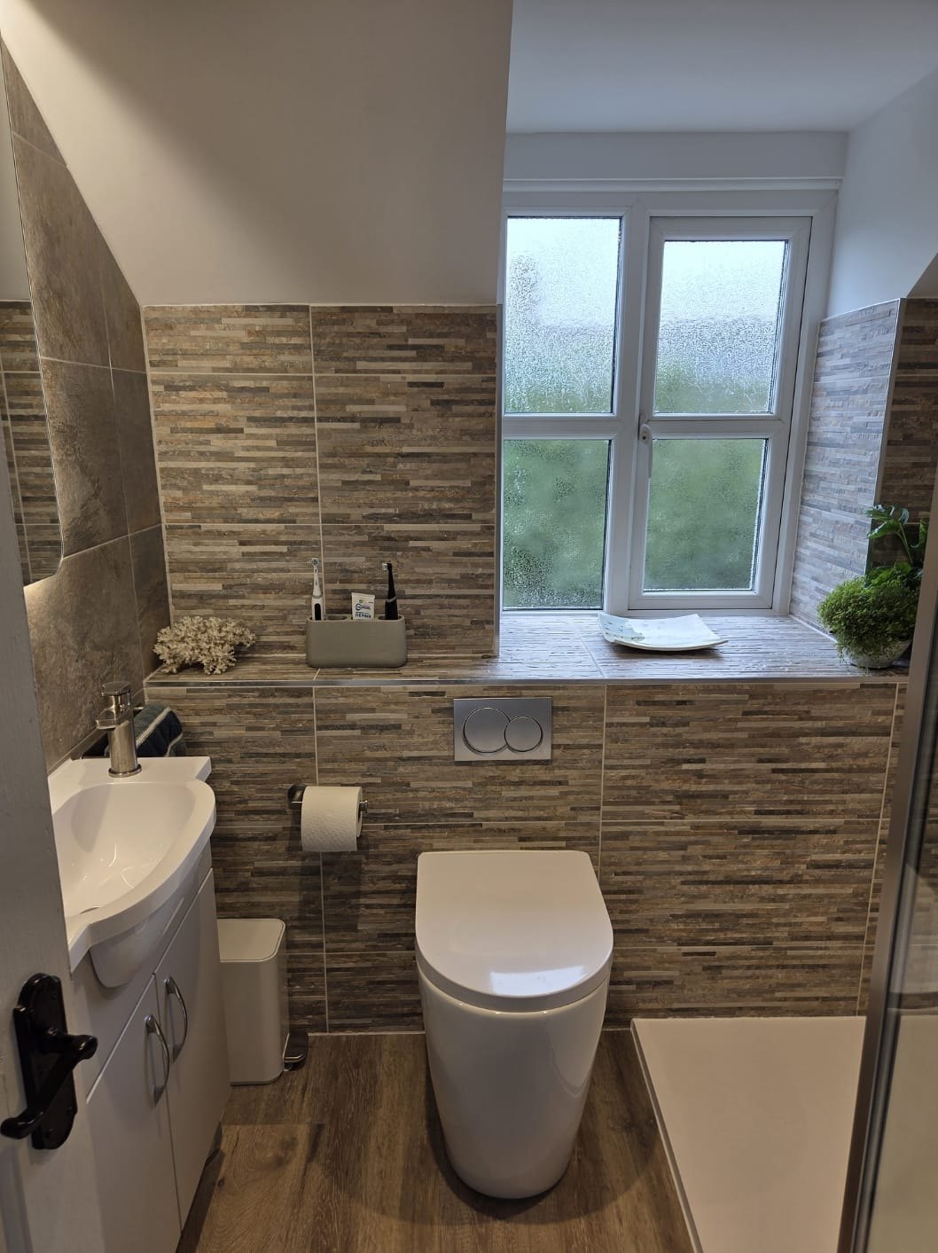 Bathroom with a stone mosaic feature wall and wall-hung toilet