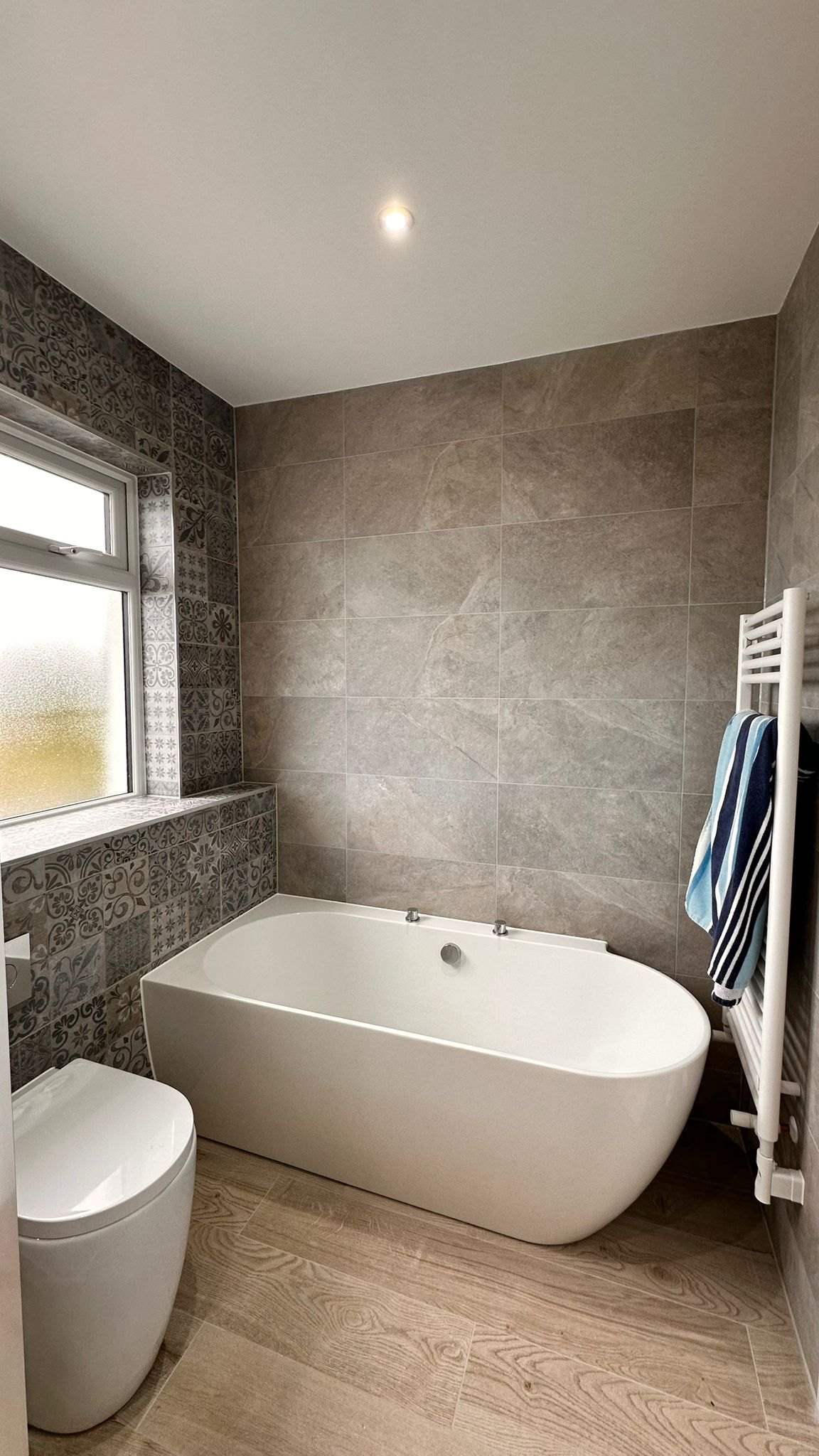 Bathroom with a freestanding-style bath and grey tiles