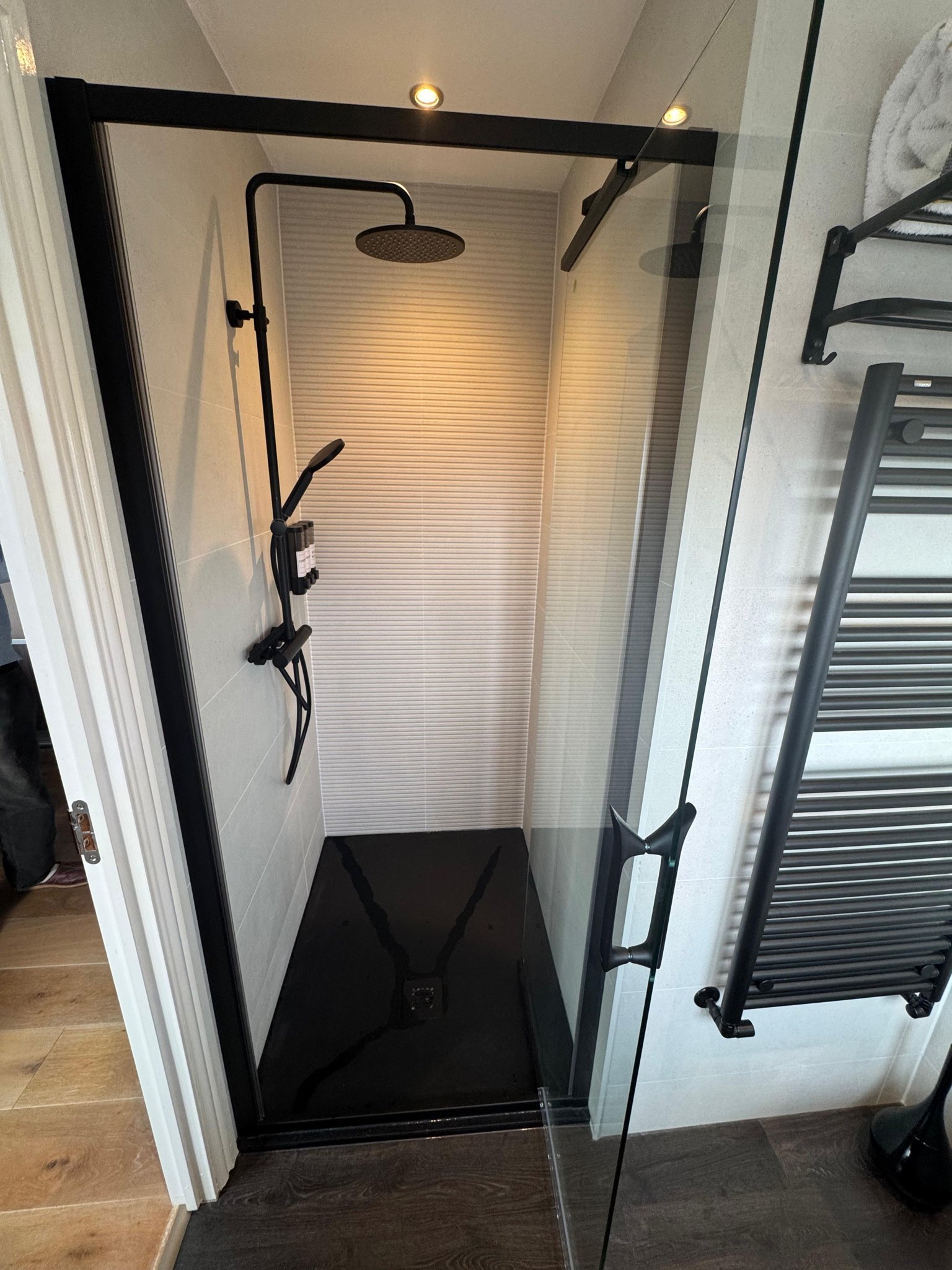 Shower with a black frame and black towel radiator