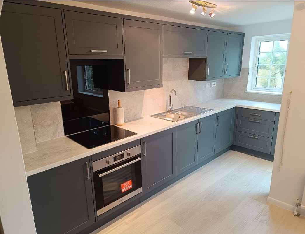 Green-grey shaker kitchen with a built-in oven and induction hob